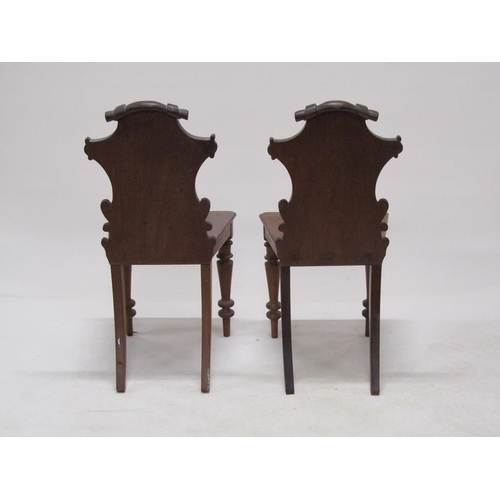 313 - A pair of Victorian mahogany hall chairs with shield carved backs, solid seats and baluster ring tur... 