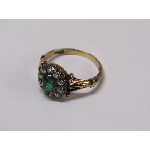 115 - An 18ct diamond and emerald ring with a central stone surrounded by ten diamonds, size L.