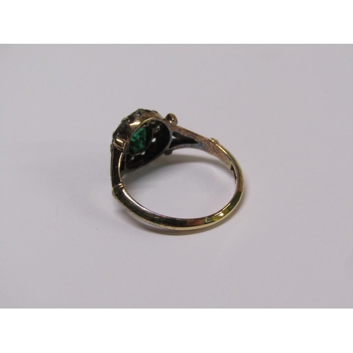 115 - An 18ct diamond and emerald ring with a central stone surrounded by ten diamonds, size L.