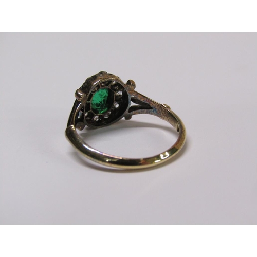 115 - An 18ct diamond and emerald ring with a central stone surrounded by ten diamonds, size L.