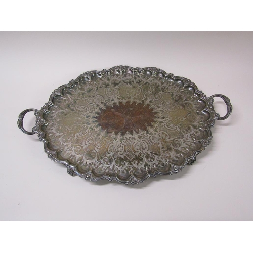 152 - A late Victorian two handled silver plated tea tray with a raised and cast border and engraved with ... 