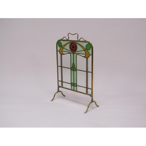 41 - A brass framed Art Nouveau glass fire screen with stylistic coloured glass floral decoration, 48cm w... 