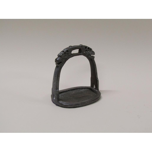 48 - A 19c Chinese/Tibetan iron stirrup with cast dragon masks, silver inlay, 12cm w, 14cm h.