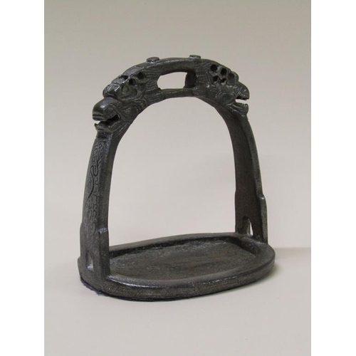 48 - A 19c Chinese/Tibetan iron stirrup with cast dragon masks, silver inlay, 12cm w, 14cm h.