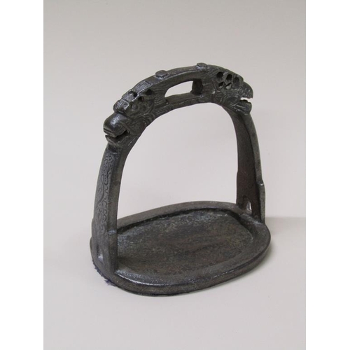 48 - A 19c Chinese/Tibetan iron stirrup with cast dragon masks, silver inlay, 12cm w, 14cm h.