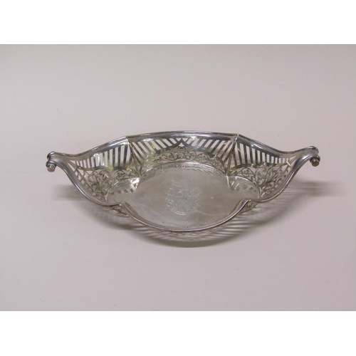 137 - A late Victorian silver basket of boat shaped form with a  raised pierced border and scrolling termi... 