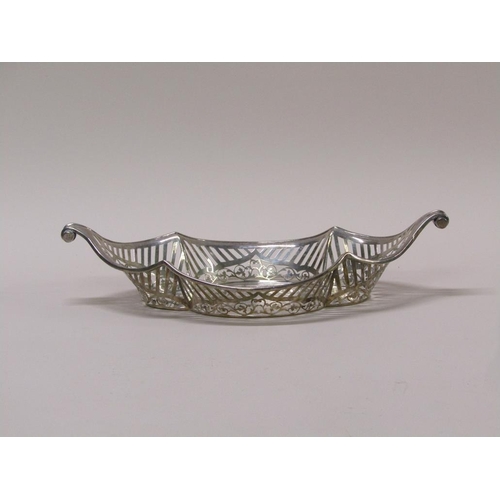 137 - A late Victorian silver basket of boat shaped form with a  raised pierced border and scrolling termi... 