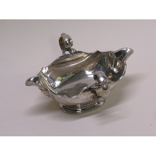 138 - A Georgian style silver sauce tureen, double lipped and having two scrolling handles, London 1972, 2... 