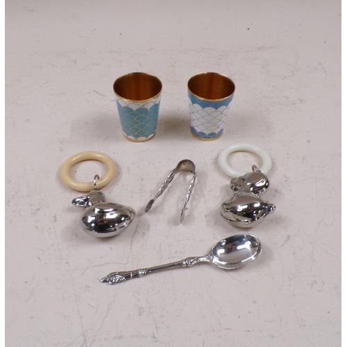 1667 - SILVER SPOON AND TONGS, TWO GILT METAL ENAMELLED TOTS AND TWO DUCK BABY RATTLES