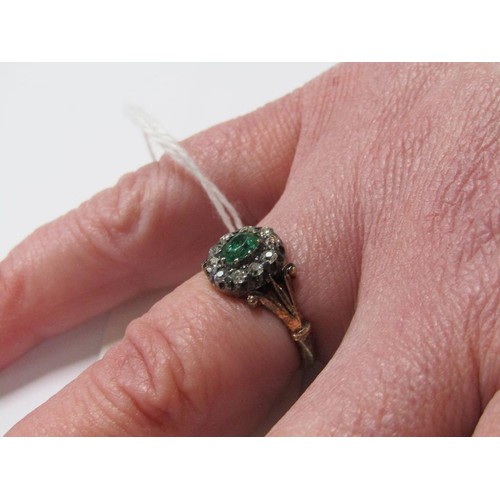 115 - An 18ct diamond and emerald ring with a central stone surrounded by ten diamonds, size L.