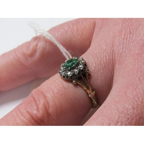 115 - An 18ct diamond and emerald ring with a central stone surrounded by ten diamonds, size L.