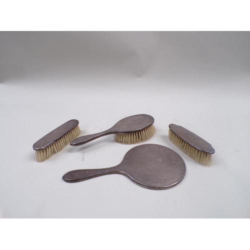 1689 - SET OF THREE SILVER BACKED BRUSHES AND A HAND MIRROR