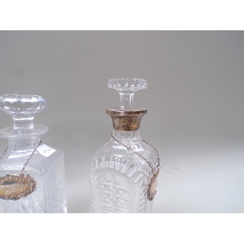 1662 - TWO CUT GLASS DECANTERS, ONE WITH A SILVER COLLAR AND TWO SILVER BOTTLE LABELS FOR WHISKY AND GIN