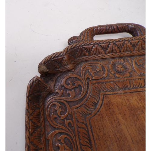 1442 - TWO CARVED WOODEN TWO HANDLED TRAYS, EACH 55cms