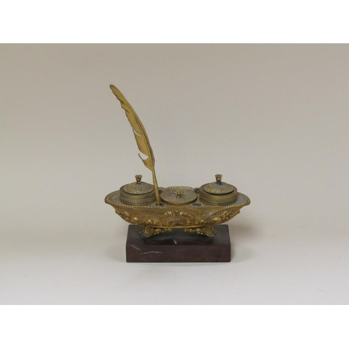 53 - A late 19c gilt metal pen and inkstand of boat shaped form with dip pen receptacles, a central box f... 