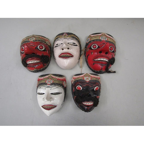 1357 - FIVE ORIENTAL CARVED WOODEN MASKS, 20CM H