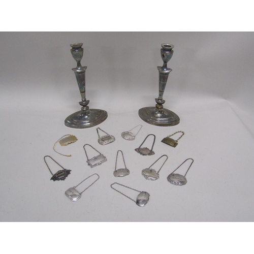 1729 - TWO SILVER PLATED CANDLESTICKS AND A QTY OF BOTTLE LABELS