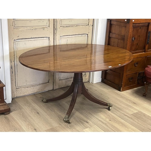 1074 - Antique English Regency mahogany oval snap top breakfast table, of large size, with string inlaid to... 