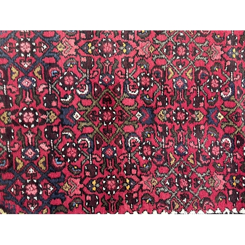 1126 - Hand knotted wool carpet of red ground, approx 182 cm x 95 cm