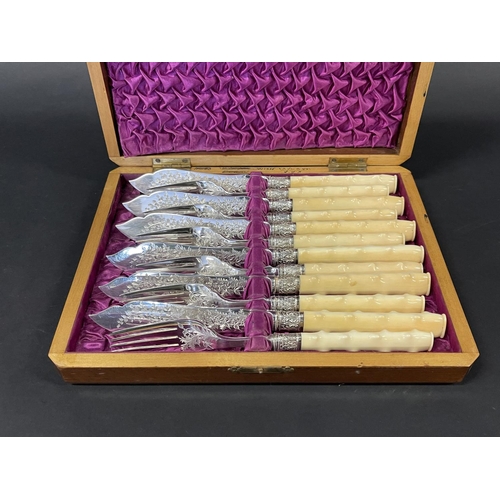1134 - Cased set of antique fish knives and forks, with hawthorn branch form ivory handles, bright cut deco... 
