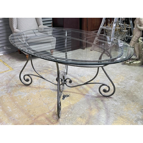 1154 - Oval Glass top table with scrolling metal base, approx 77cm H x 190cm W x 119cm D