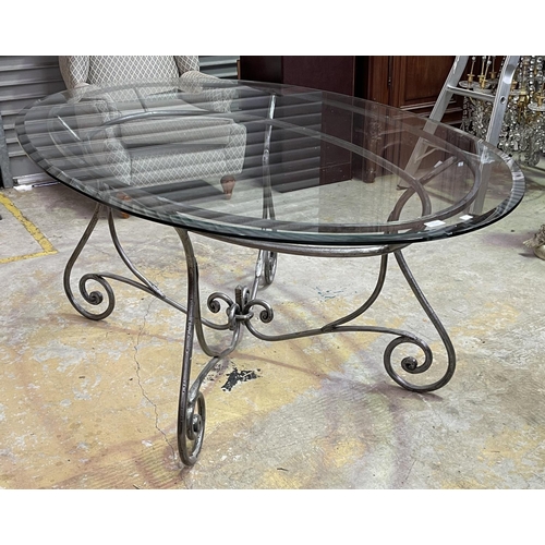 1154 - Oval Glass top table with scrolling metal base, approx 77cm H x 190cm W x 119cm D