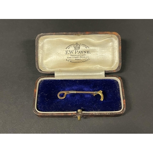 1182 - 14ct gold brooch, in the form of a riding crop, detailed 14ct, approx 2g, with a fitted box (2)