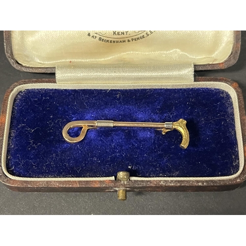 1182 - 14ct gold brooch, in the form of a riding crop, detailed 14ct, approx 2g, with a fitted box (2)