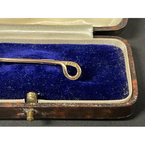 1182 - 14ct gold brooch, in the form of a riding crop, detailed 14ct, approx 2g, with a fitted box (2)