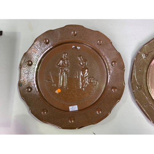 277 - Two large French hand worked copper wall trays, decorated in relief,  each approx 50cm Dia (2)