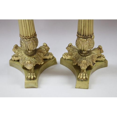 24 - Pair of antique French Empire style gilt candlesticks, having lion paw feet and fluted columns, each... 