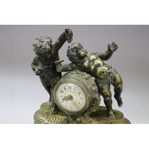 52 - Antique French figural ladies desk clock, surmounted with two putti, one feeding grapes, the other w... 
