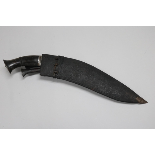 36 - Metal hilt kukri with scabbard. The hilt is decorated with chiselled decorative patterns that are/we... 