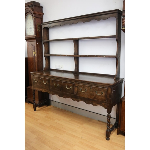 1005 - Antique English 17th century style oak dresser with open plate rack over three drawers on barley twi... 