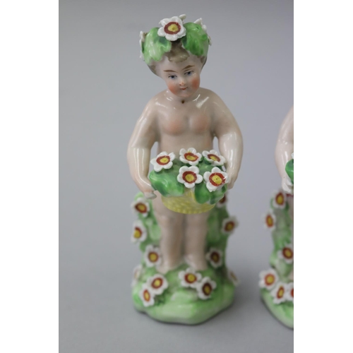 18 - Pair of Derby style porcelain putti with baskets of flowers, each approx 11.5cm H (2)