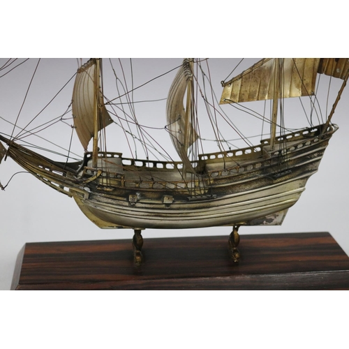 252 - Silver plate three mast ship, on dolphin supports attached to wooden base, approx 31cm H x 29cm W