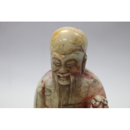 72 - Antique early 20th century Chinese two colour jade figure of a god, holding a sceptre, wooden base, ... 
