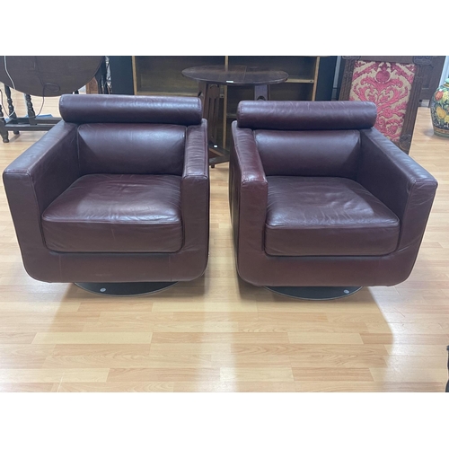 284 - Pair of Natuzi single chairs with a swivel bases, organic maroon leather, cylinder bolster head rest... 