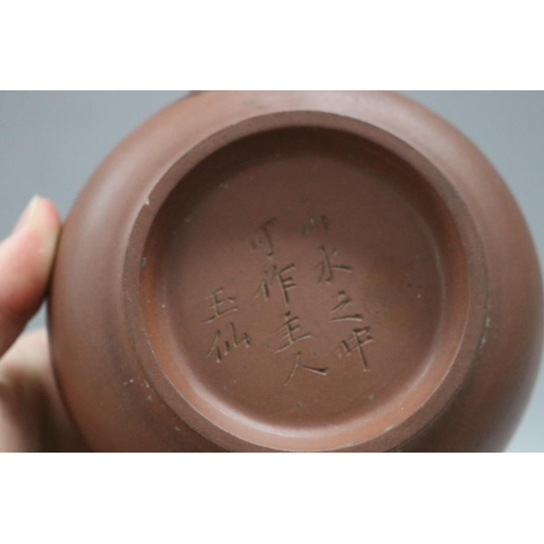 73 - Two Yixing Zhusha clay tea pots, one with raised painted decoration, the other of squat plain form, ... 