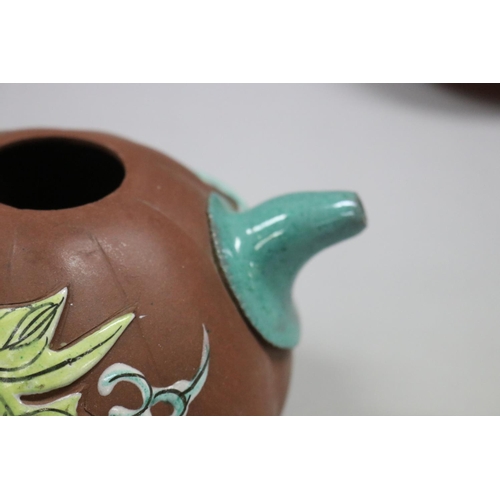 73 - Two Yixing Zhusha clay tea pots, one with raised painted decoration, the other of squat plain form, ... 