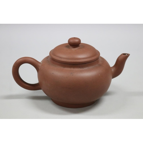 73 - Two Yixing Zhusha clay tea pots, one with raised painted decoration, the other of squat plain form, ... 