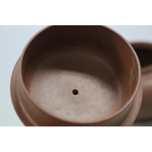 73 - Two Yixing Zhusha clay tea pots, one with raised painted decoration, the other of squat plain form, ... 