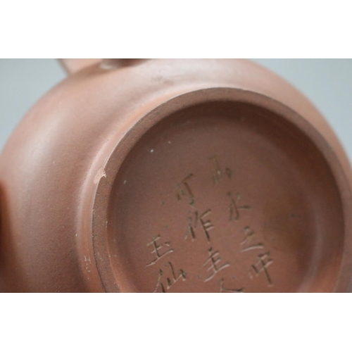 73 - Two Yixing Zhusha clay tea pots, one with raised painted decoration, the other of squat plain form, ... 