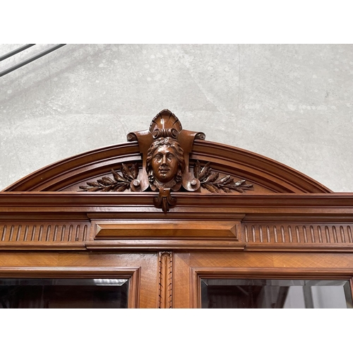 103 - Pair of French walnut two height bookcases, each with a carved in high relief female mask central ca... 