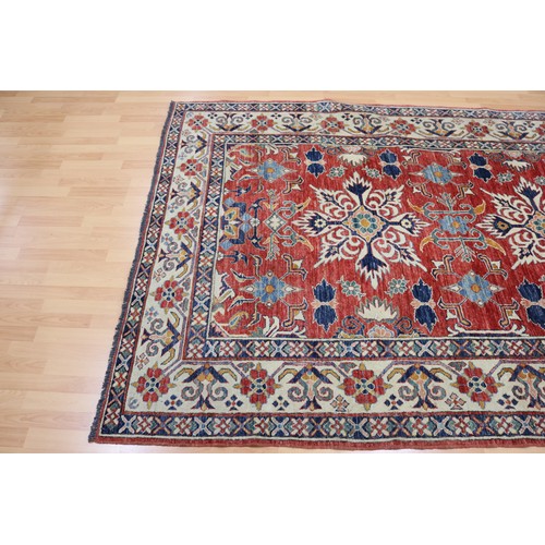 159 - Good Afghan hand knotted wool carpet, with ivory borders and central central red ground, with floral... 