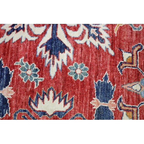 159 - Good Afghan hand knotted wool carpet, with ivory borders and central central red ground, with floral... 