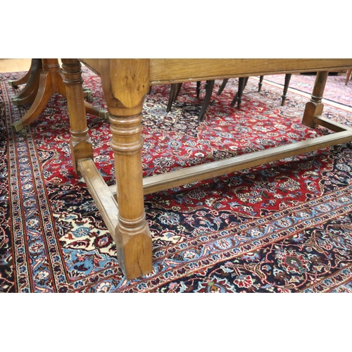 287 - English oak slab top period revival trestle table, with central long stretcher, held by turned block... 