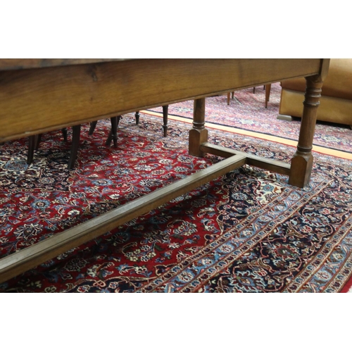 287 - English oak slab top period revival trestle table, with central long stretcher, held by turned block... 