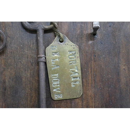70 - Antique French iron keys on wooden backboard, approx 40cm x 22cm