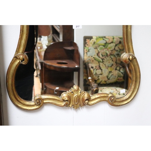 217 - Antique style waisted shape gilt surround mirror, approx 90cm H x 61cm W